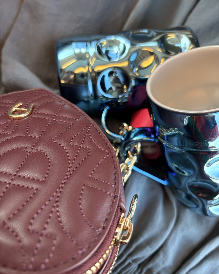 Blaue Krüge neben einer burgunderroten Tasche