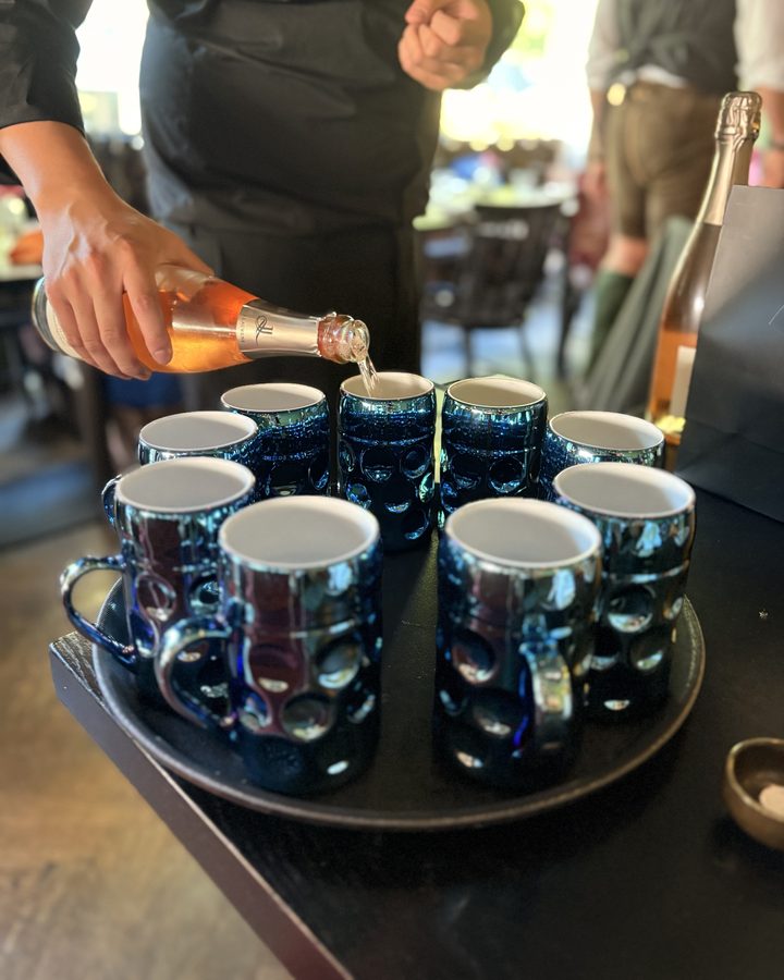 Sekt wird in die blauen Krüge eingeschenkt